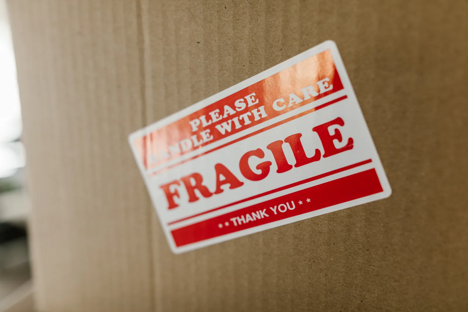 Close-up of a cardboard box with a 'fragile' sticker indicating careful handling.